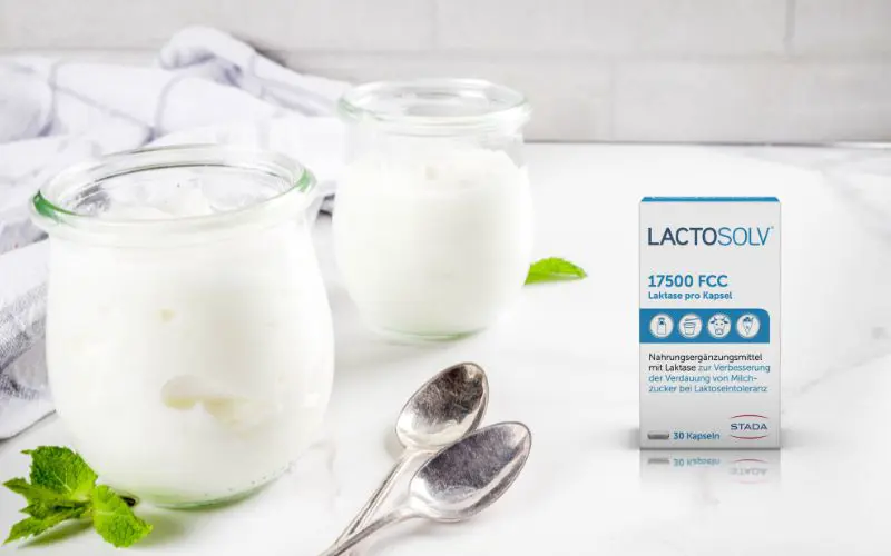 Joghurtgläser mit Löffel, daneben Lactosolv