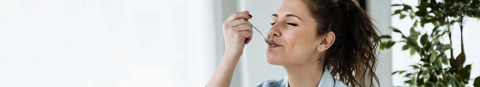 Ernährung bei Migräne: Frau mit Löffel im Mund