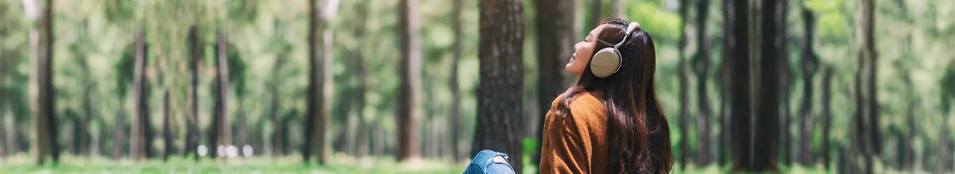 Frau hört im Grünen Musik