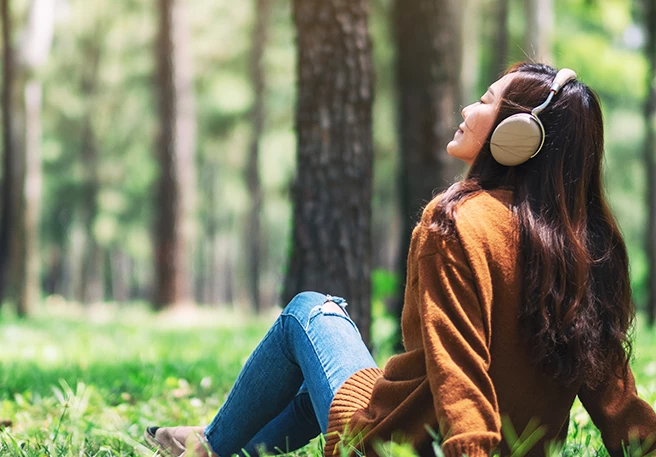 Frau hört im Grünen Musik