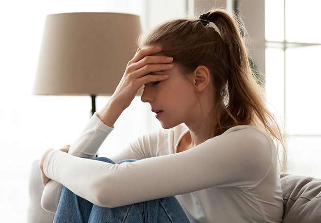 Frau fasst sich an die Stirn | Migräneattacke