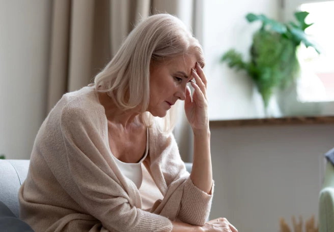 Frau fasst sich an die Stirn | Migräneattacke