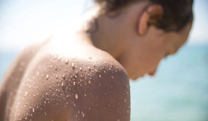 Frau mit nasser Haut am Strand 