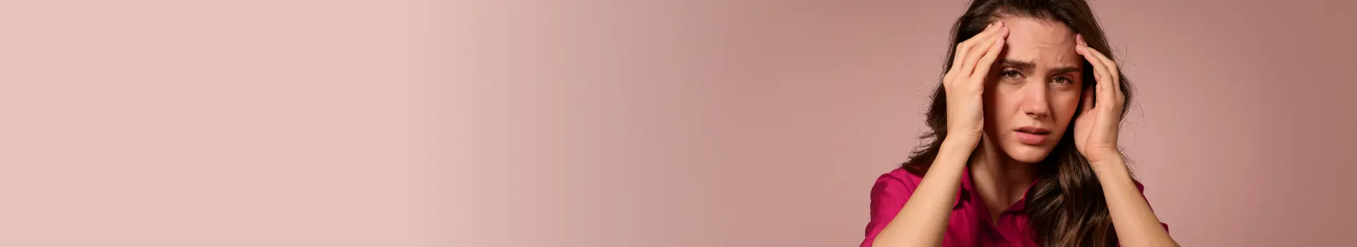 Frau fasst sich mit beiden Händen an die Schläfen